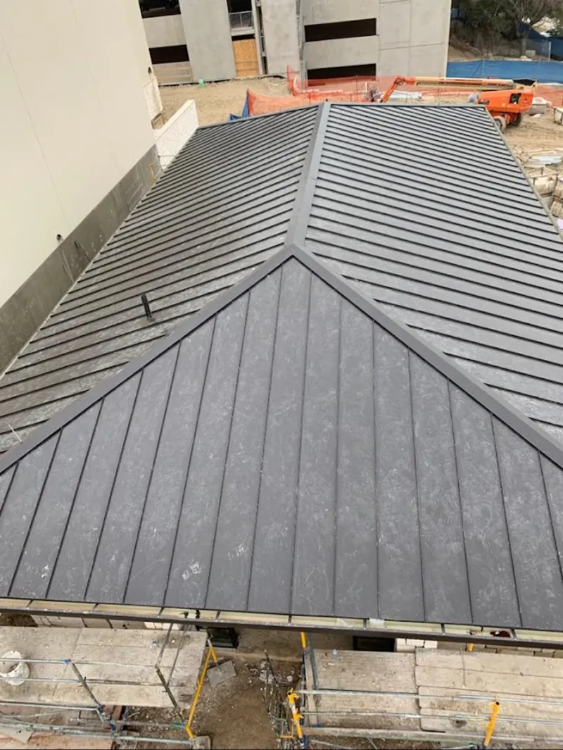 Commercial metal roof construction with crane equipment in Martic
